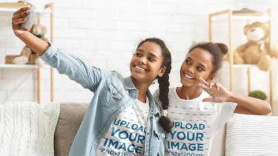 Mockup of Two Sisters Taking a Selfie While Wearing T-Shirts