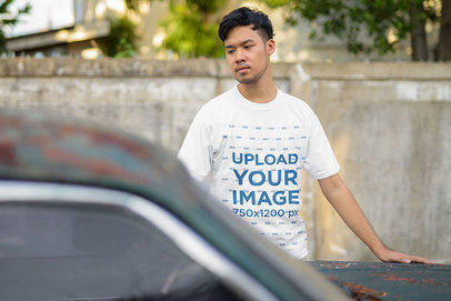 T-Shirt Mockup of a Serious Man Standing by an Old Car 