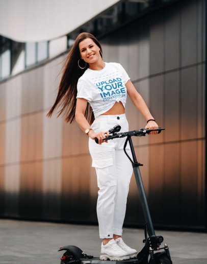 Mockup of a Woman Wearing a Knotted Tee While Riding a Scooter