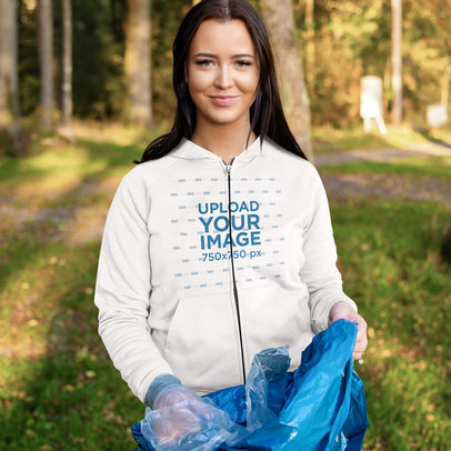  Mockup of a Woman Wearing a Full-Zip Hoodie While Cleaning a Park 