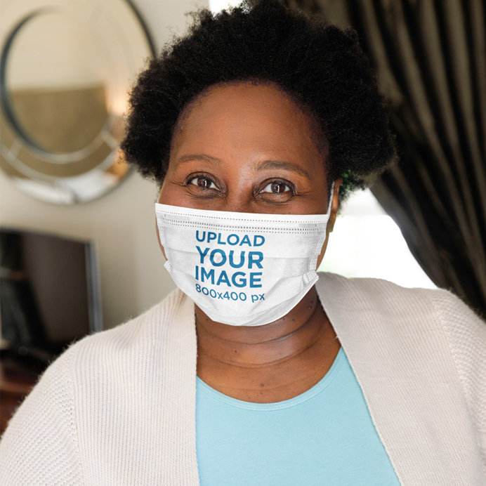 Mockup of a Happy Curly-Haired Woman Wearing a Sublimated Face Mask 