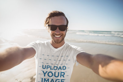 T-Shirt Mockup of a Happy Man Taking a Selfie at the Beach