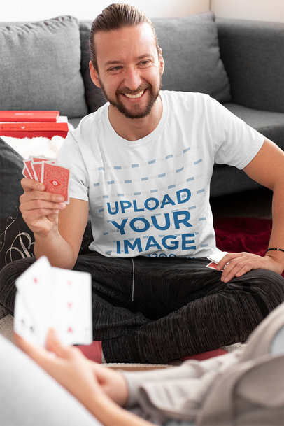 T-Shirt Mockup of a Bearded Man Playing Cards at Home