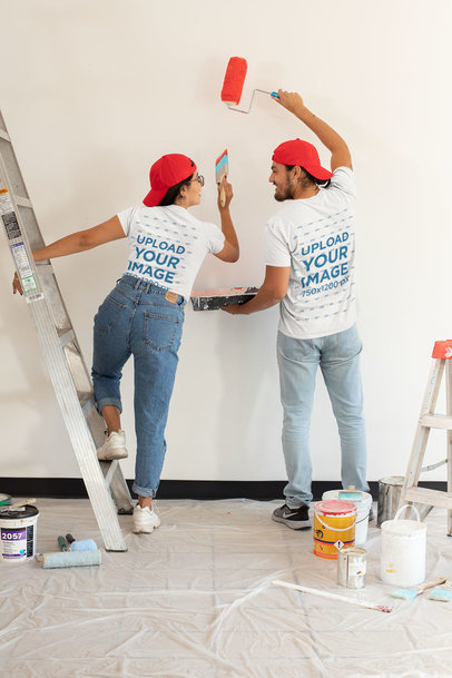 Back-View T-Shirt Mockup Featuring a Couple Painting a Wall