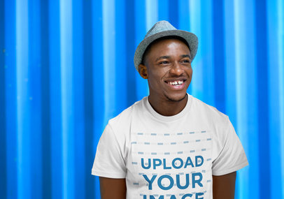 T-Shirt Mockup of a Smiling Man by a Colorful Wall