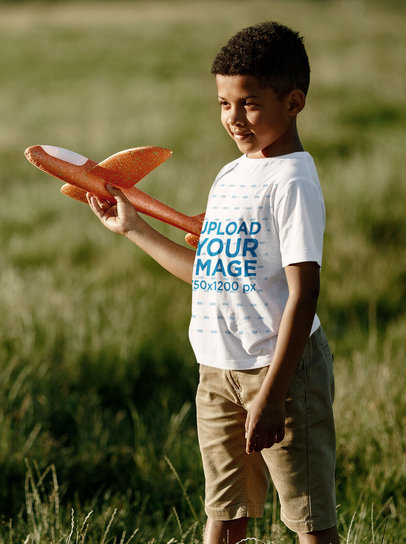 T-Shirt Mockup of a Boy Playing With a Toy Airplane