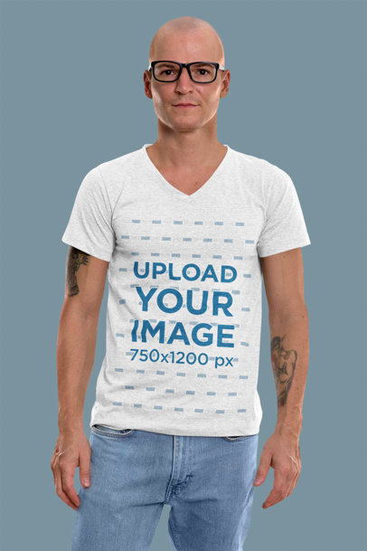 T-Shirt Mockup Featuring a Tattooed Man Standing in a Studio