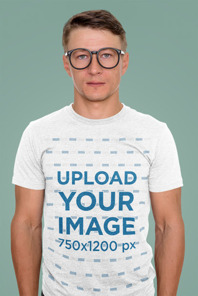 T-Shirt Mockup of a Serious Man with Glasses Standing in a Studio