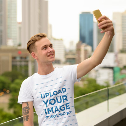 Basic T-Shirt Mockup of a Young Man Taking a Selfie 