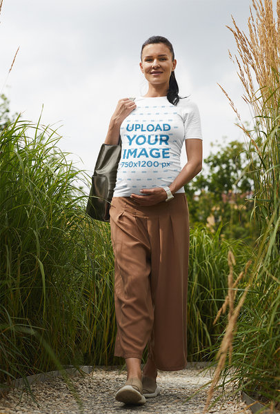 Tee Mockup of a Pregnant Woman Walking Through a Garden