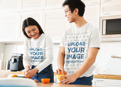 Long Sleeve Tee and T-Shirt Mockup of a Young Couple Making Orange Juice in the Kitchen
