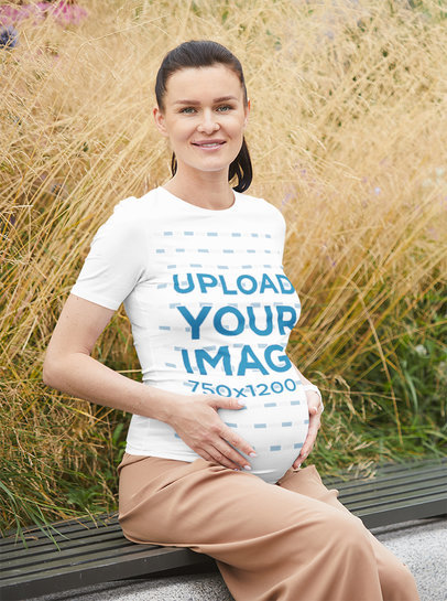 T-Shirt Mockup of a Pregnant Woman Sitting in a Garden