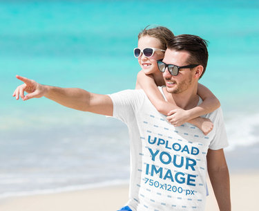 T-Shirt Mockup of a Man at the Beach Carrying His Daughter 