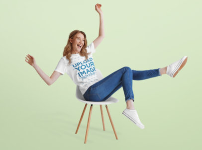 T-Shirt Mockup of a Happy Woman Sitting on a Chair at a Studio 