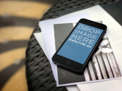 Mockup of an iPhone 5S Placed over some Photographs