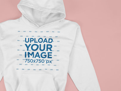 Closeup Mockup of a Pullover Hoodie Lying on a Solid Surface