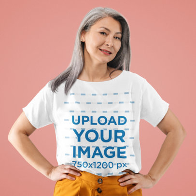 T-Shirt Mockup Featuring a Senior Woman Posing at a Studio 