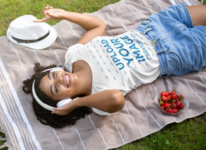 T-Shirt Mockup Featuring a Young Woman Lying on a Blanket in the Garden 
