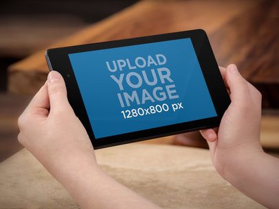 Mockup of a Woman Holding a Nexus 7 in Landscape Mode