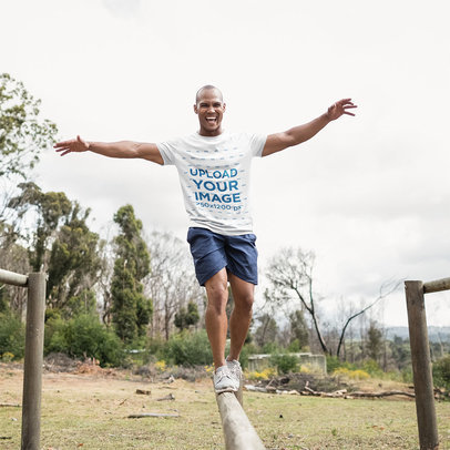 Round-Neck Tee Mockup of a Man Walking over a Log