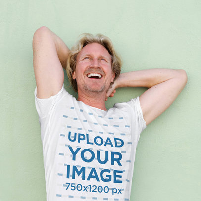 T-Shirt Mockup Featuring a Smiling Man Lying over a Solid Surface 37371-r-el2