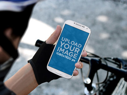 Overshoulder Mockup of a Man on a Bike Holding a Samsung Galaxy S4