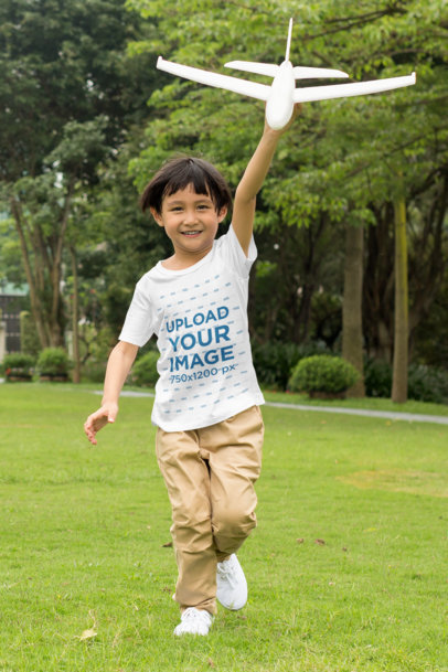 T-Shirt Mockup of a Happy Kid Playing with a Toy Plane