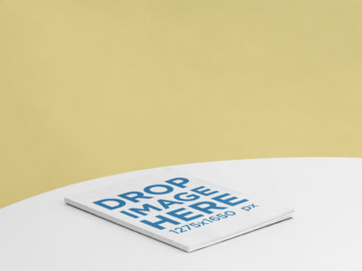 Magazine Mockup Lying on a Round Table Against a Solid Color Background