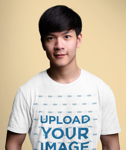 Heather T-Shirt Mockup of a Young Man Standing Against a Colored Backdrop