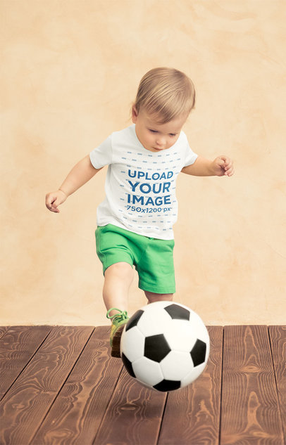 Mockup of a Little Boy Wearing a T-Shirt and Playing With a Soccer Ball 