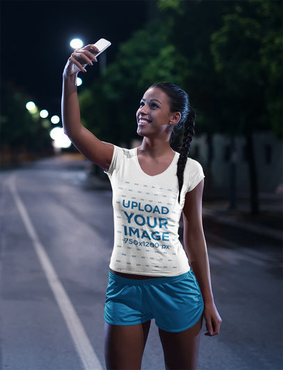 T-Shirt Mockup of a Woman Taking a Selfie After a Nocturnal Run