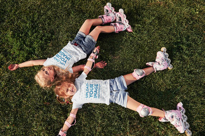 T-Shirt Mockup of Two Sisters Resting on the Grass After Roller Skating