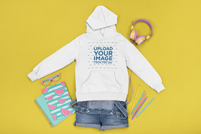 Girl's Outfit Mockup Featuring a Hoodie Placed by Colorful School Supplies 