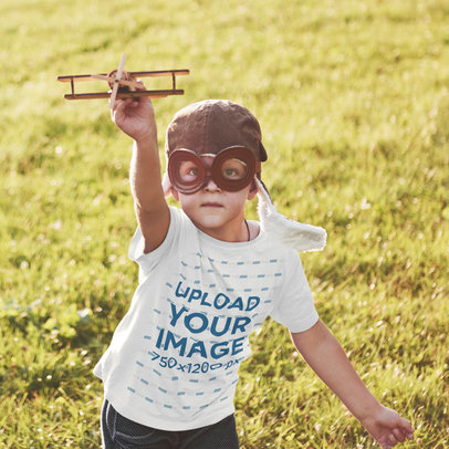 T-Shirt Mockup Featuring a Kid Playing With a Small Plane 