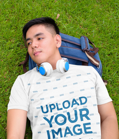 T-Shirt Mockup of a Young Man Lying on the Grass