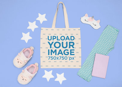 Mockup of a Flat Laid Tote Bag Featuring a Kid's Sleeping Outfit