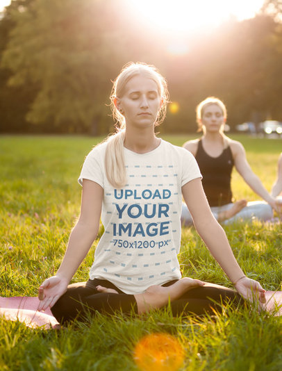 T-Shirt Mockup of a Woman Meditating Sitting on the Grass