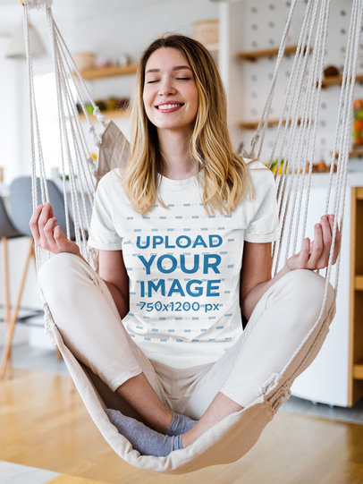 T-Shirt Mockup of a Smiling Woman Meditating on a Hammock at Home