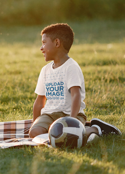 T-Shirt Mockup of a Smiling Boy at a Park with a Soccer Ball