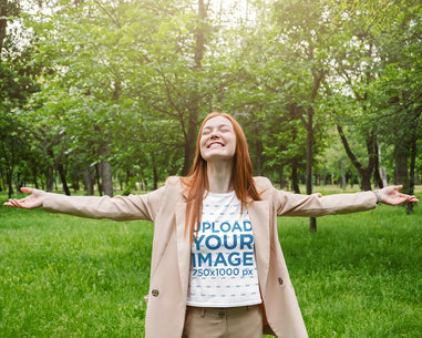 Tee Mockup of a Joyful Woman with Arms Wide Open at the Woods