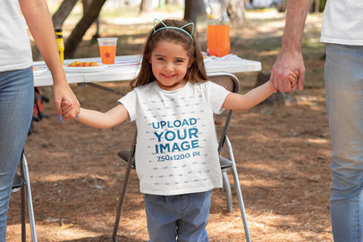 T-Shirt Mockup Featuring a Little Girl Holding Her Parent's Hands 