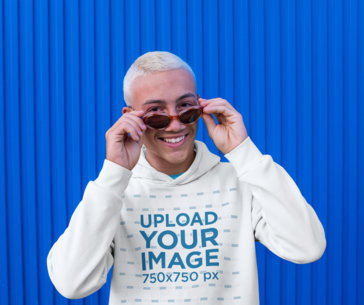 Hoodie Mockup Featuring a Happy Young Man Posing Against a Blue Wall m1972-r-el2