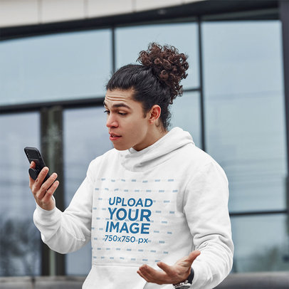 Pullover Hoodie Mockup of a Surprised Man Looking at His Phone 