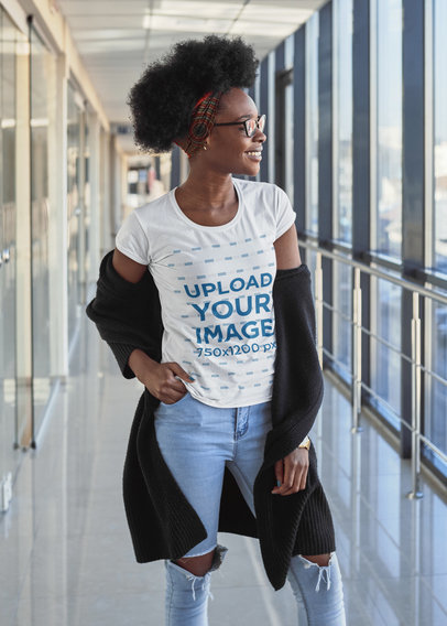 Basic T-Shirt Mockup of a Happy Curly-Haired Woman Posing at a Corridor