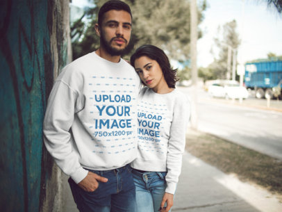 Mockup of a Couple Wearing Different Crewneck Sweatshirts Designs While Hugging Outdoors