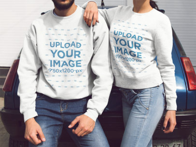 Mockup of a Couple with Cropped Face Lying on a Blue Car While Wearing Different Crewneck Sweatshirts