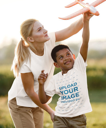 T-Shirt Mockup of a Happy Kid Playing With an Airplane Toy 
