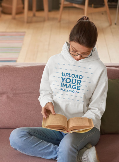 Hoodie Mockup of a Young Woman Reading on a Couch