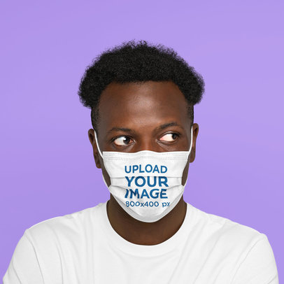 Face Mask Mockup Featuring a Curly-Haired Man Against a Plain Color Background 