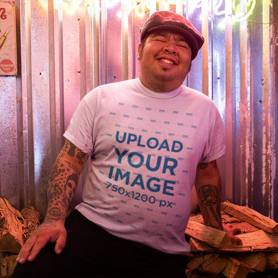 T-Shirt Mockup of a Tattooed Man Posing in a Bar